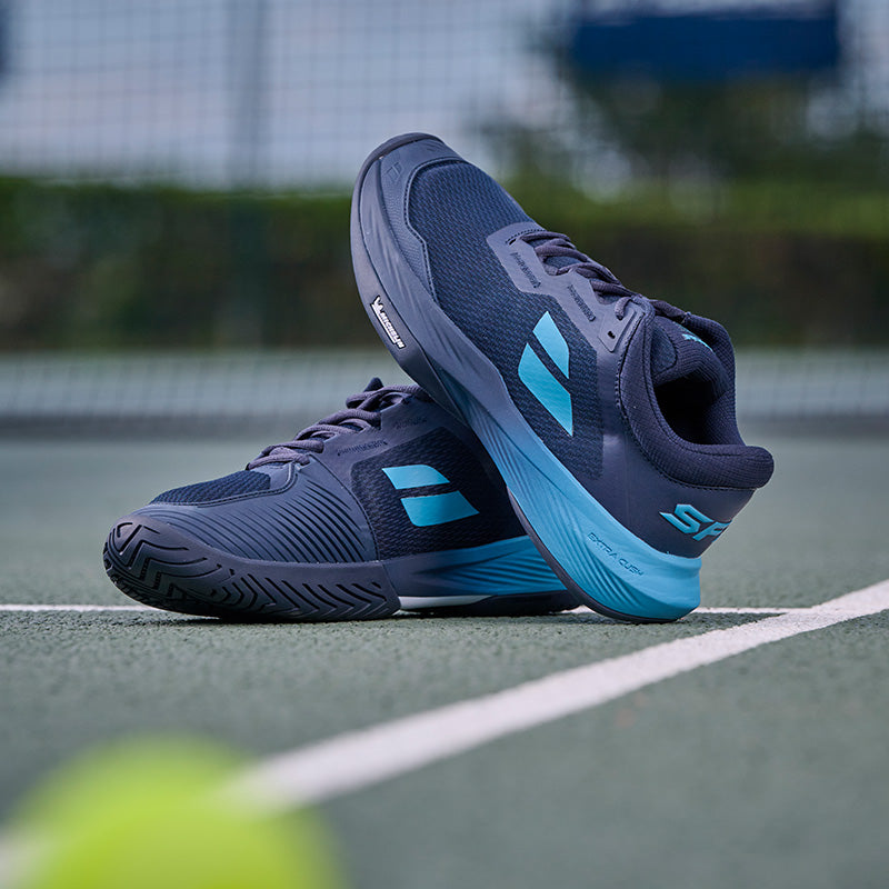 Babolat SFX 4 tennis shoes on a green court