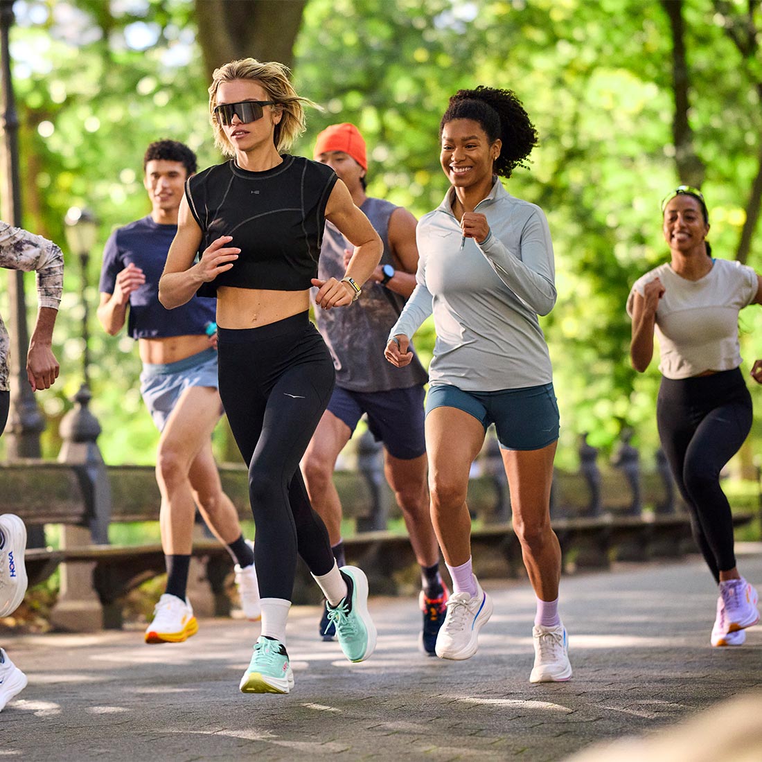 Lifestyle image of a group of people running in a park wearing HOKA Bondi 9 shoes